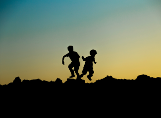 Two children silhouetted playing